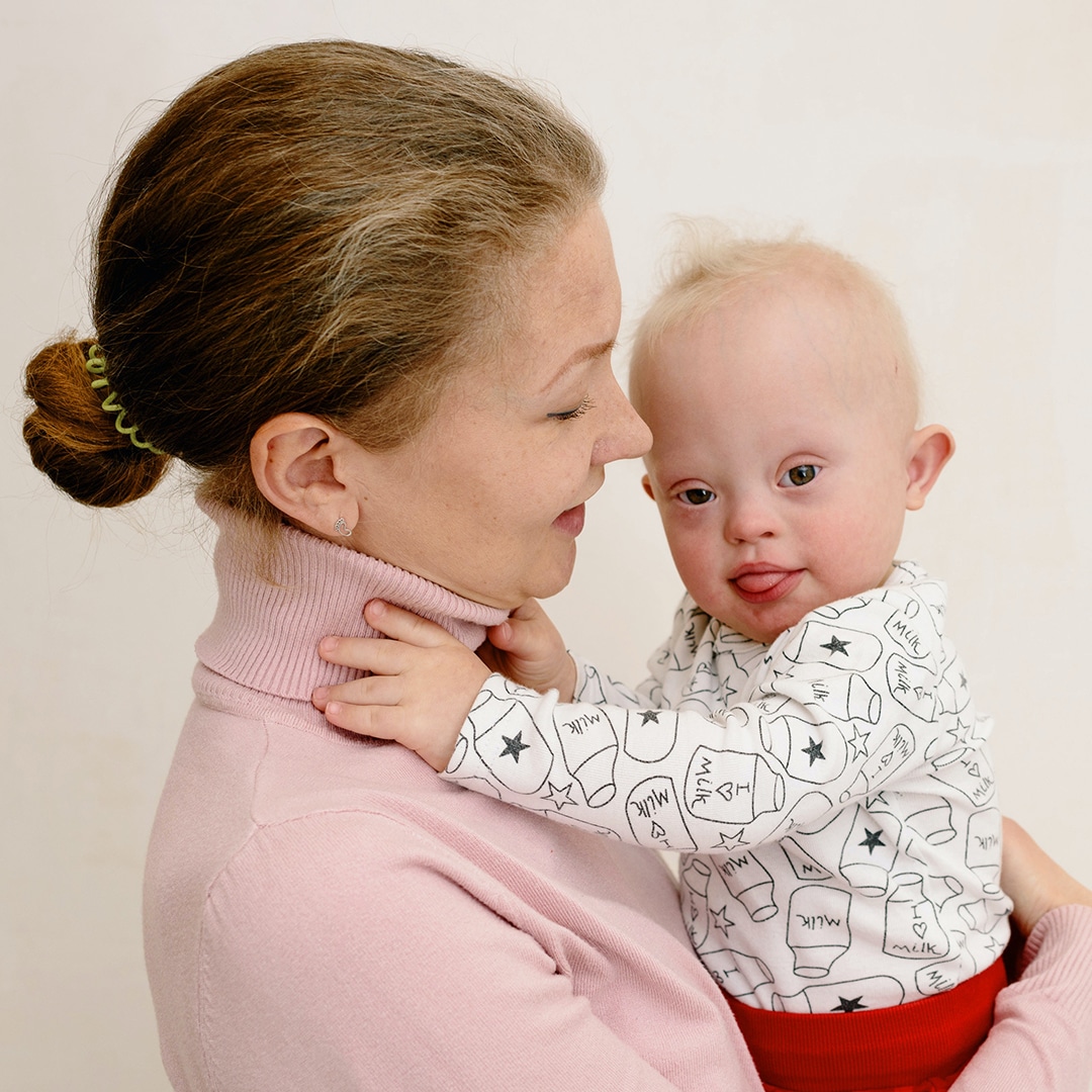 Mom holding baby with down syndrome