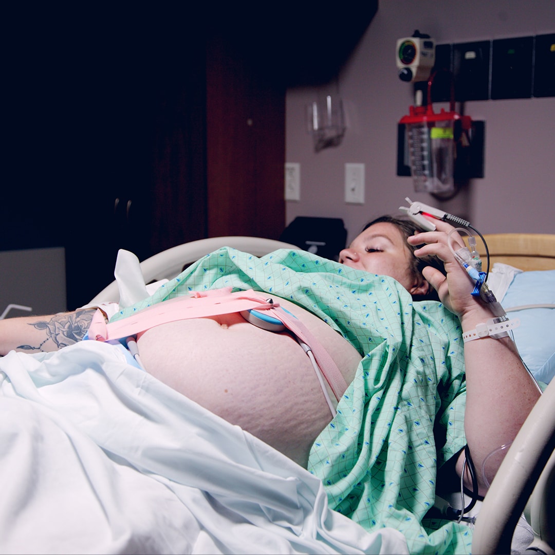 Woman laying in hospital bed with fetal monitor on