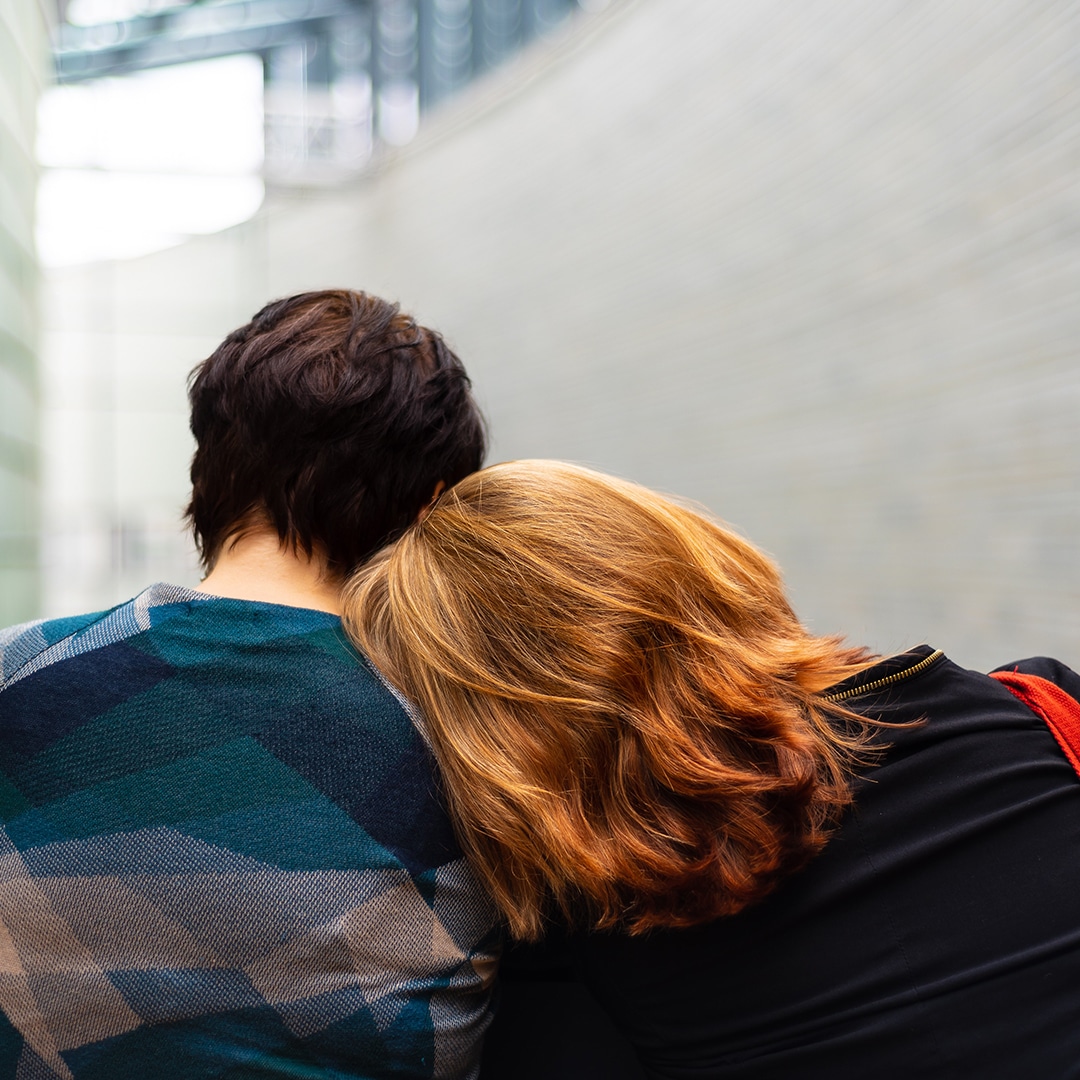 Red headed girllaying her head on a guy's shoulder