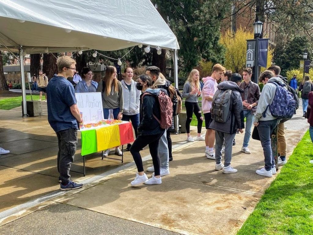 Std=udents dialoging on campus at a table